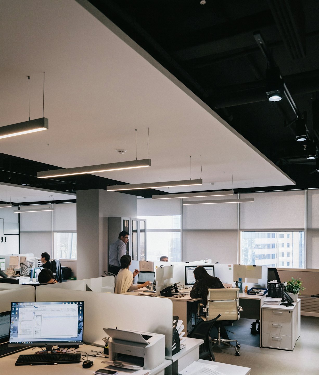Vielfältige Teammitglieder arbeiten in einem modernen Großraumbüro zusammen.